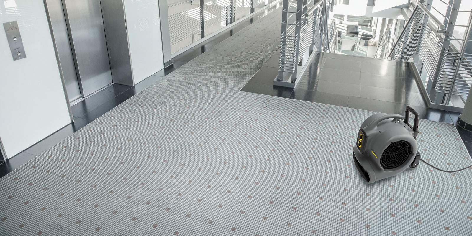 使用高潔吹風機吹乾房間地毯的圖片。