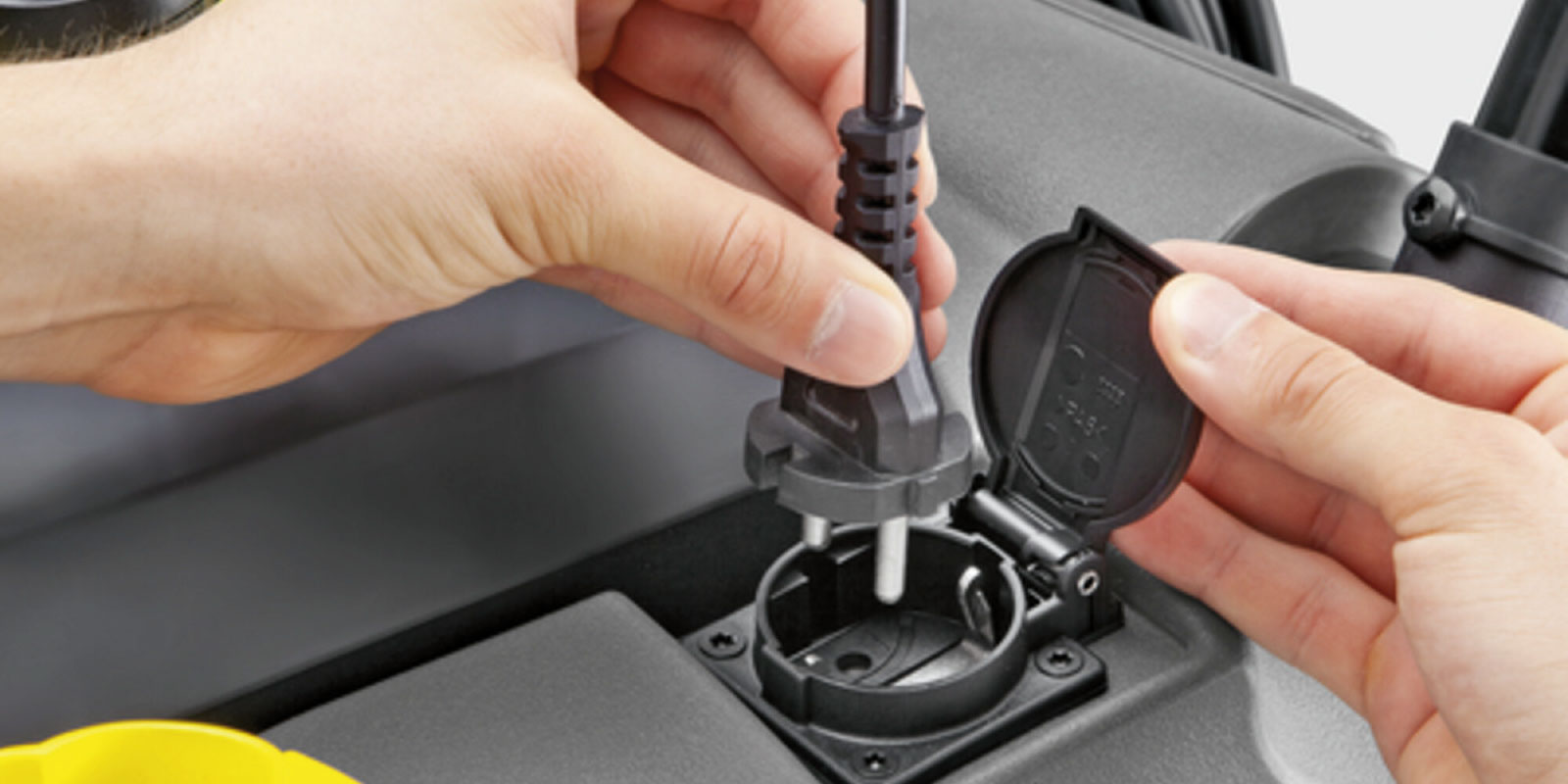 A picture of the integrated power outlet of the Kärcher spray extraction machine Puzzi 30/4.