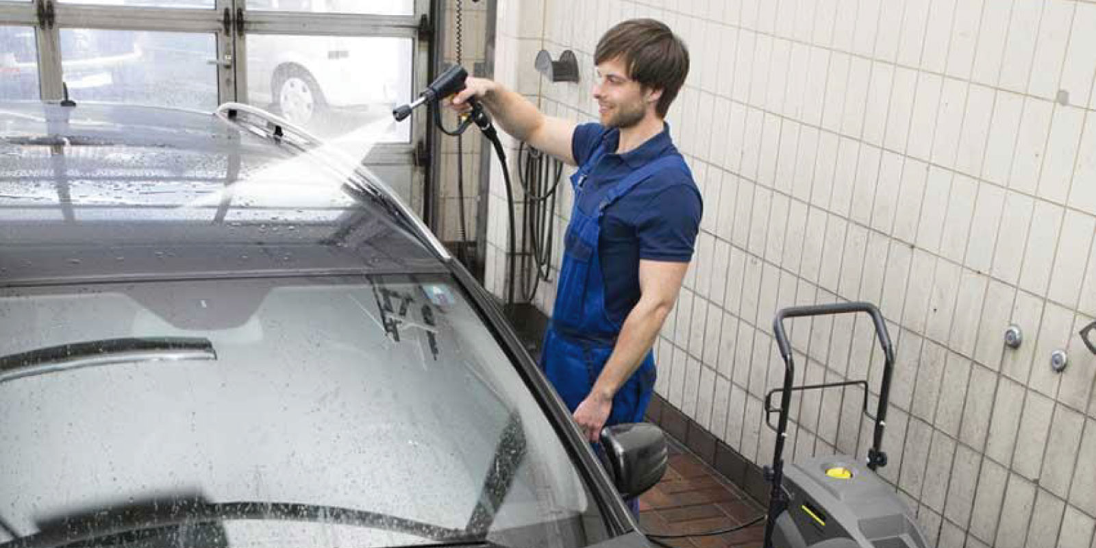 A picture of using the Kärcher cold water high-pressure cleaner HD 9/20-4 Classic to clean a car.