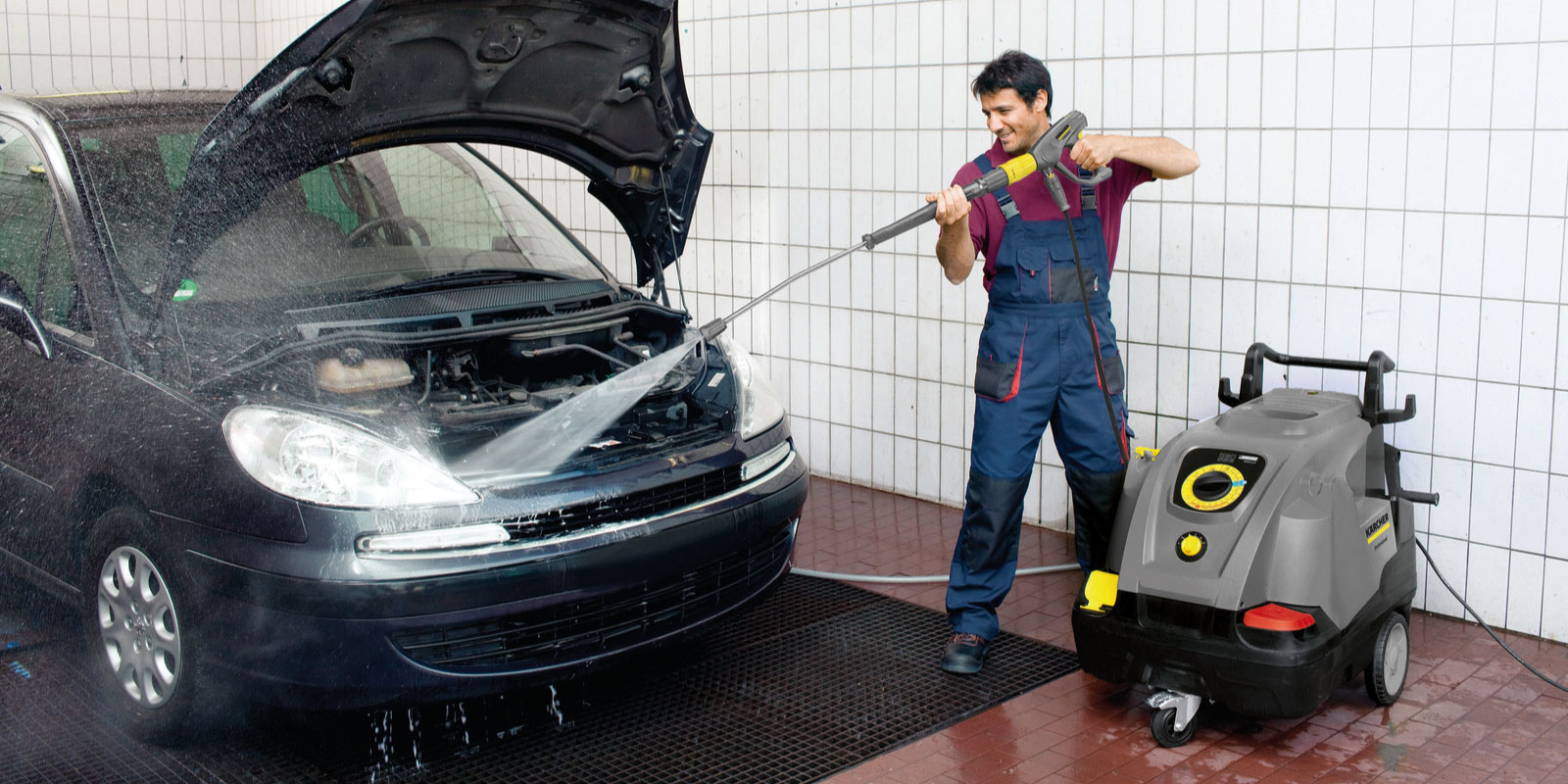 使用高潔緊湊式熱水高壓清洗機清洗汽車的圖片。
