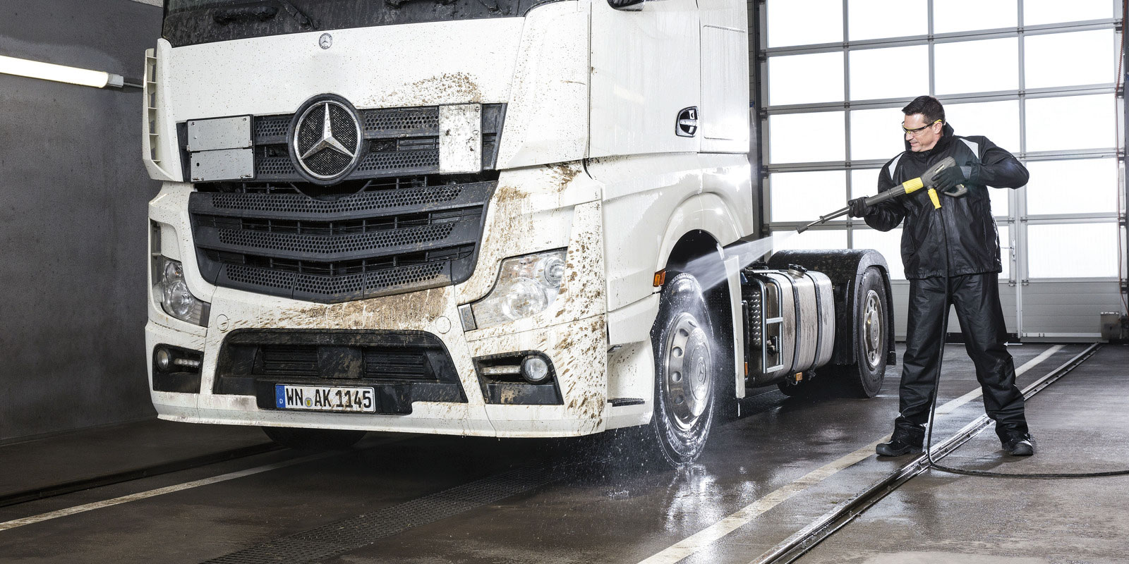 A picture of using the Kärcher hot water high-pressure cleaner HDS 10/20-4 M to clean a tractor.
